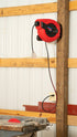 Lincoln Industrial 91039 retractable cord reel mounted on workshop wall with table saw below