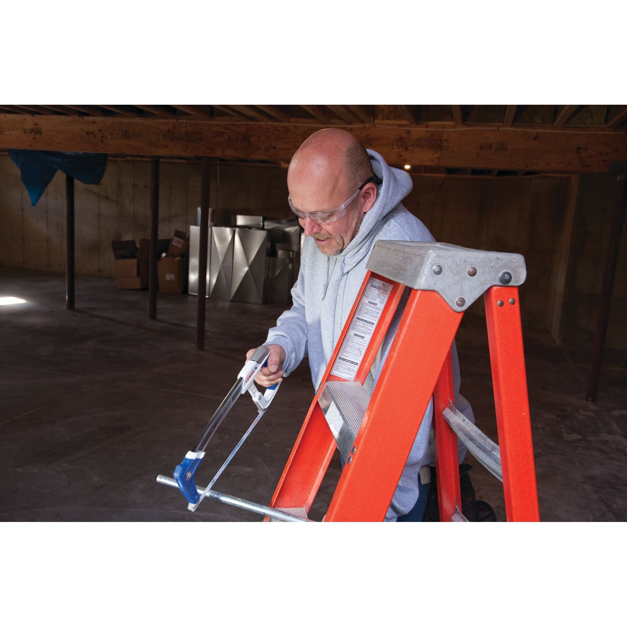 Lenox Tools High Tension Hacksaw in use cutting metal on a ladder