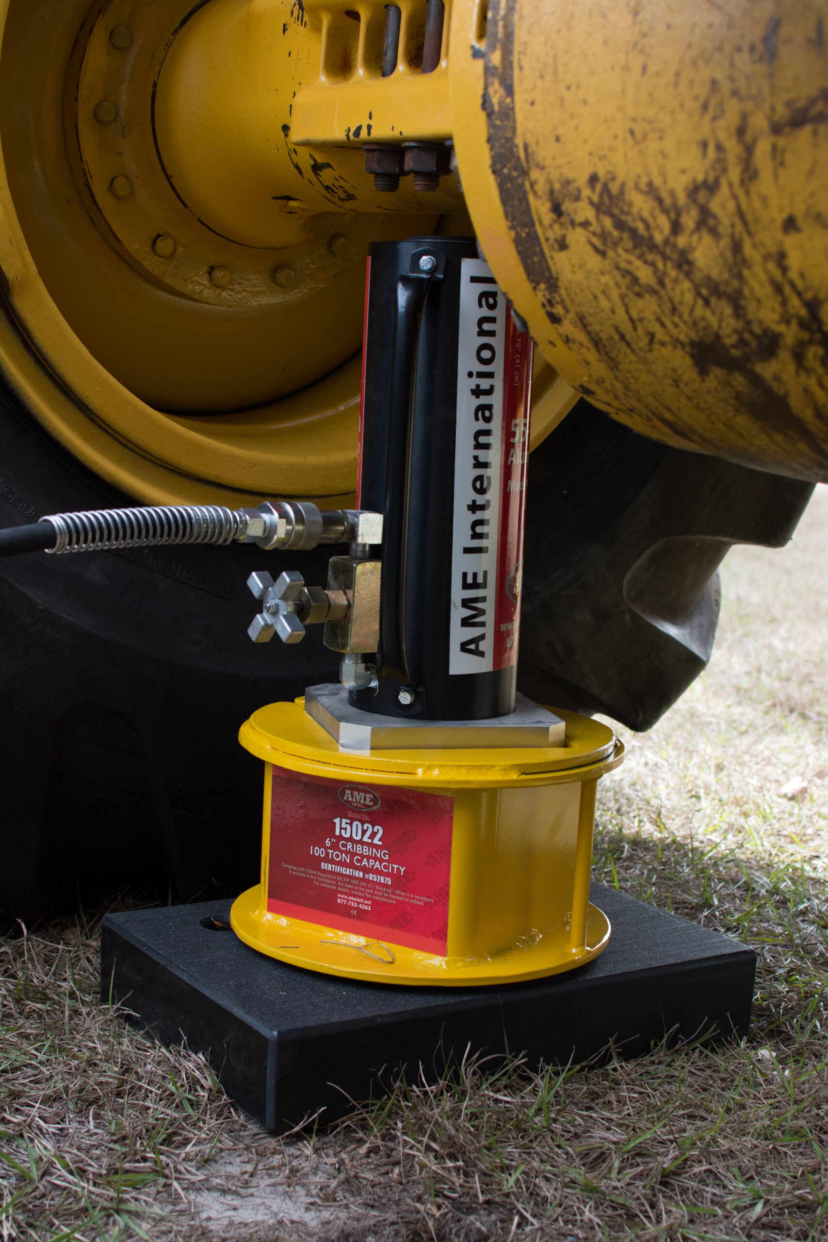 AME International 14466 Titan Jack Plate in use under heavy equipment with cribbing block