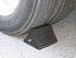 AME International 15300 Rubber Wheel Chock in use against large truck tire on pavement
