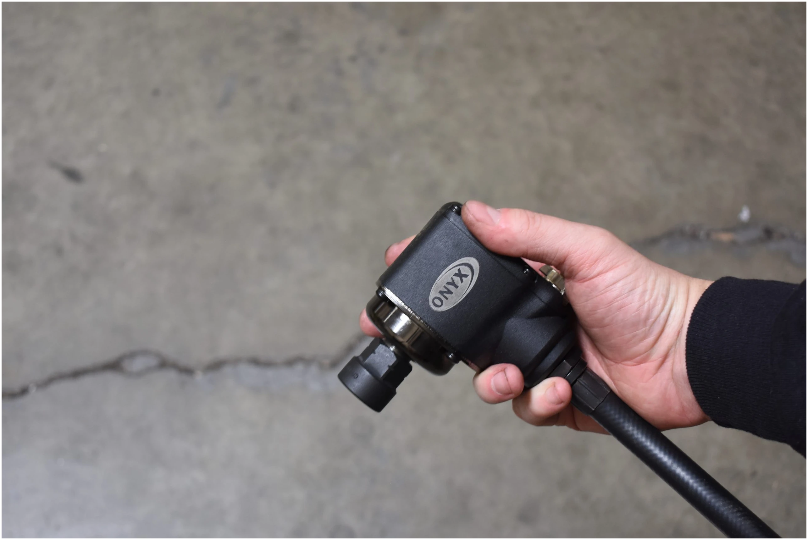 Astro Pneumatic ONYX 1/2 Inch Palm Impact Wrench held in one hand showing compact palm-grip design
