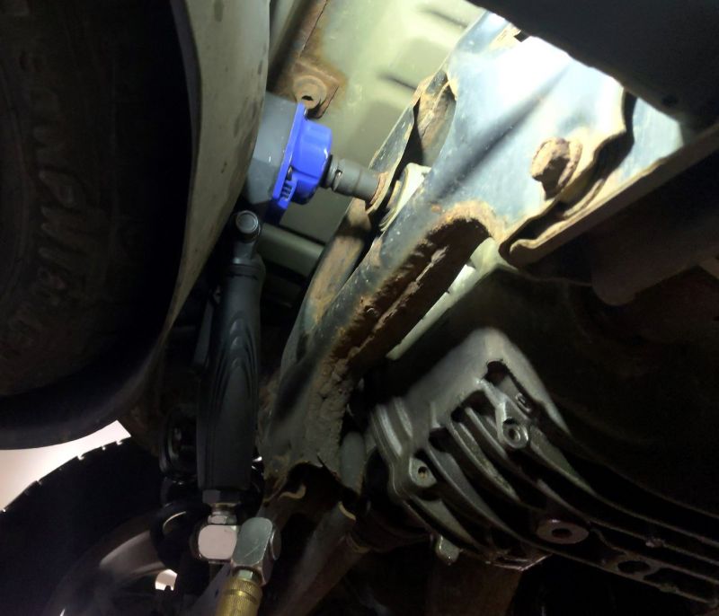 Astro Pneumatic 1834 1/2 In Nano Flex-Head Angle Impact Wrench in use under vehicle in tight space