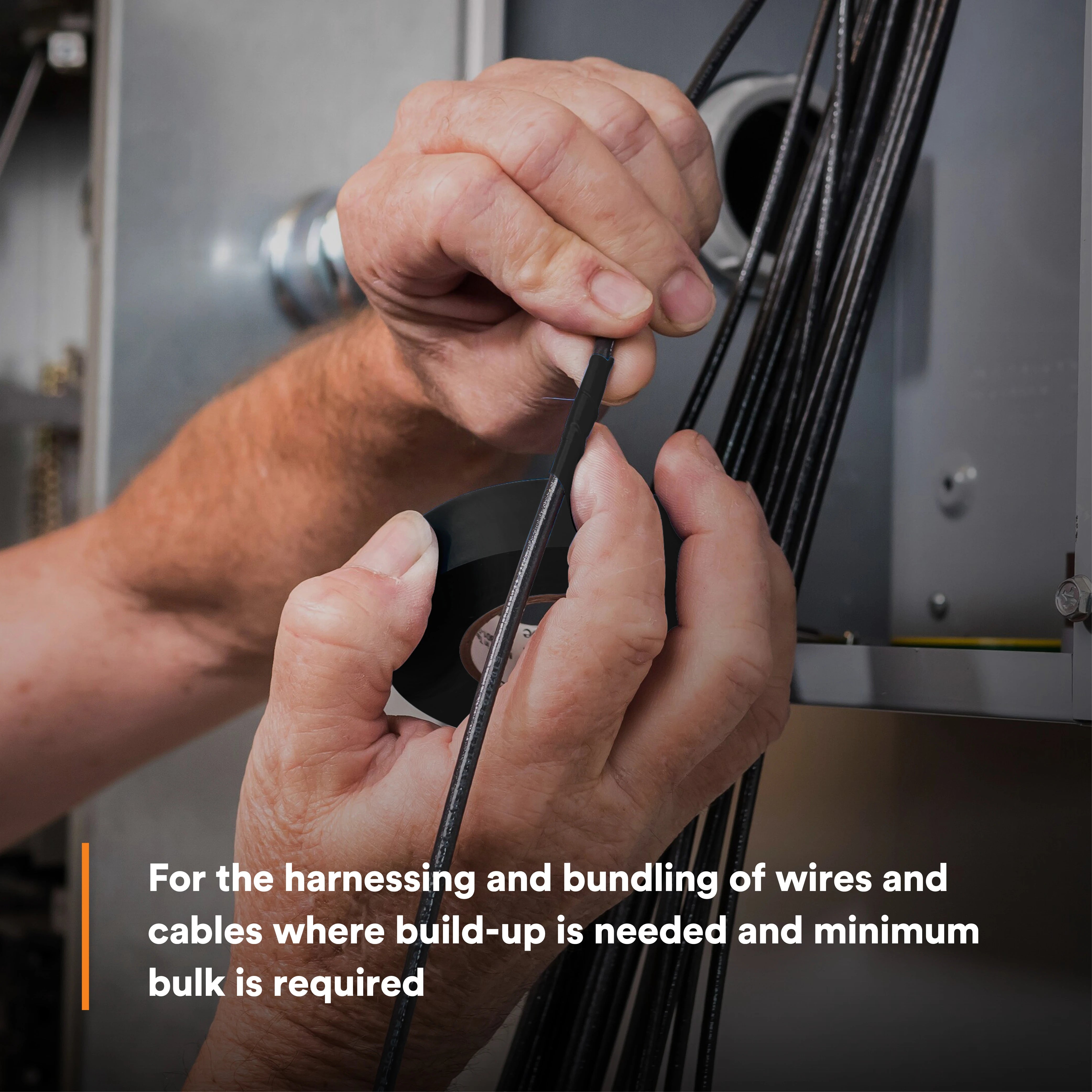 Electrician applying 3M Temflex 165 electrical tape to wire harness in an electrical panel