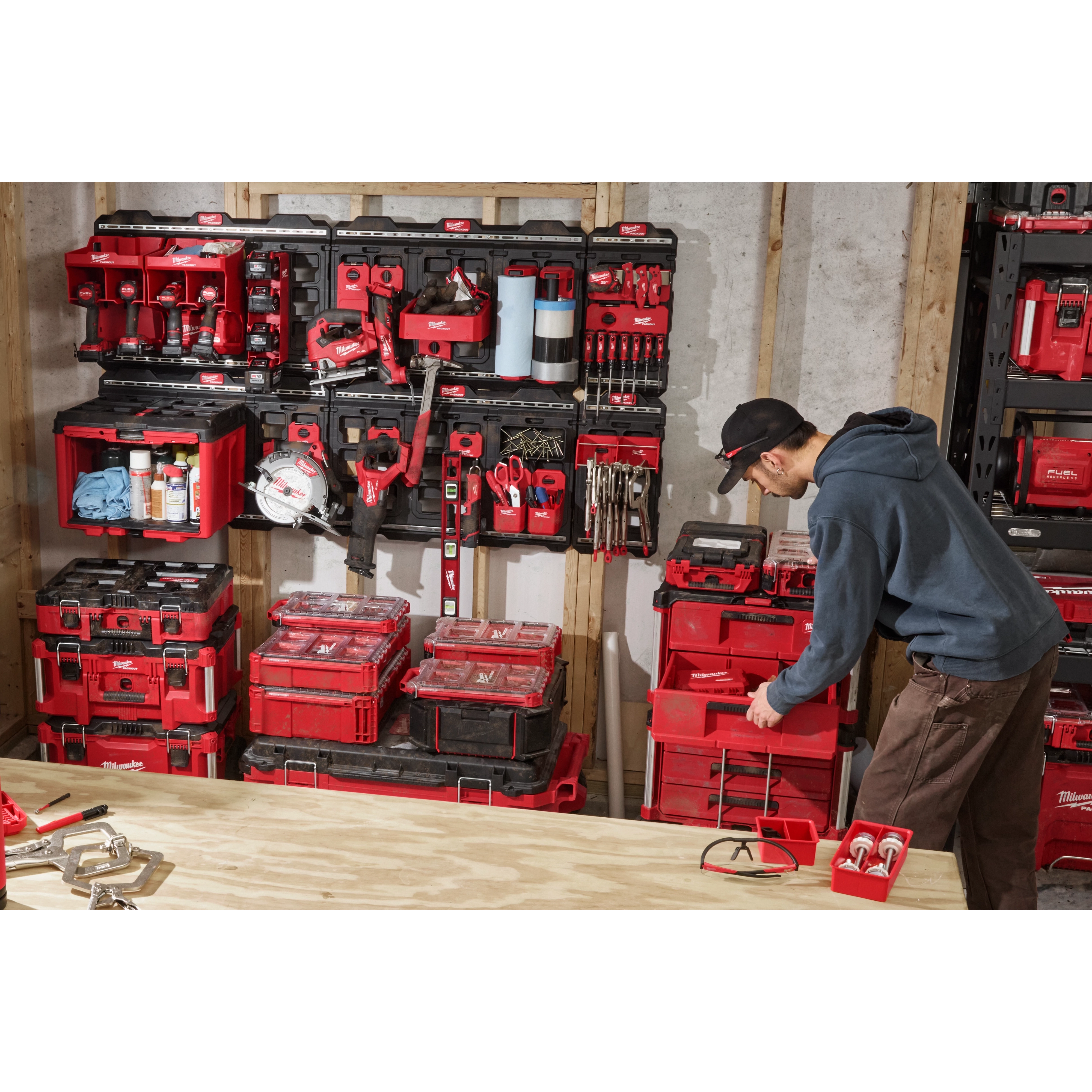 Milwaukee PACKOUT Compact Wall Plate lifestyle photo showing full modular storage system in a workshop