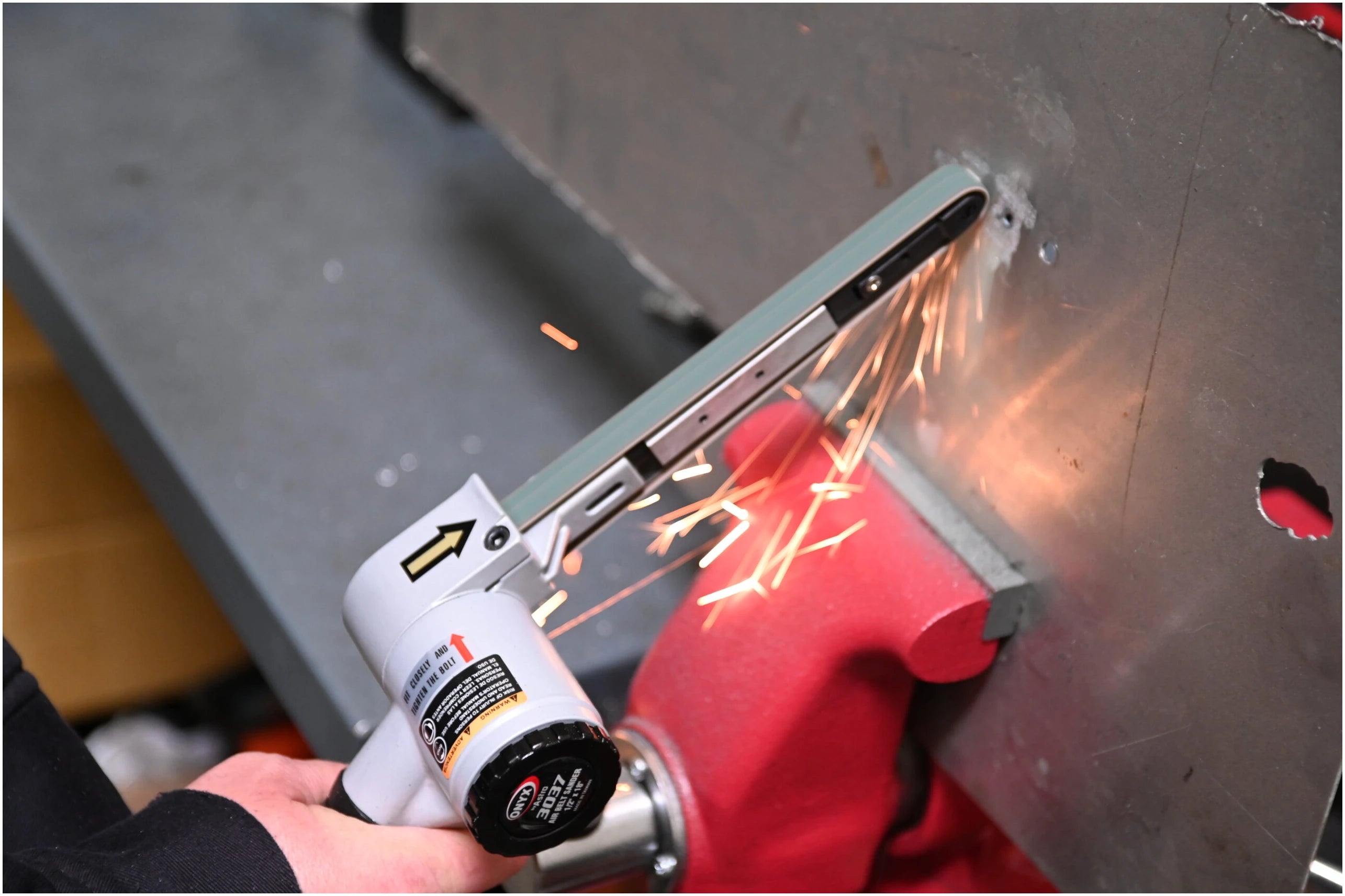 Astro Pneumatic 3037 Air Belt Sander removing spot welds from metal panel with sparks