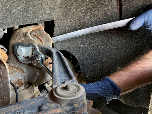 Lisle 41620 caster camber wrench in use below GM vehicle suspension by technician