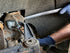Lisle 41620 caster camber wrench in use below GM vehicle suspension by technician