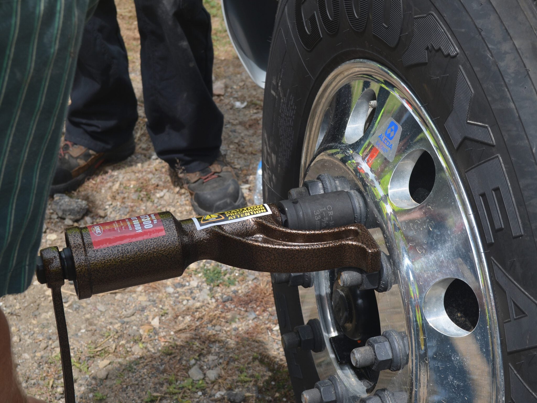 AME International 67300 Nut Buddy Lug Loosener in use on commercial truck wheel hub