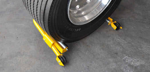 ESCO 70132 Super Wheel Dolly in use supporting a large truck tire on a shop floor