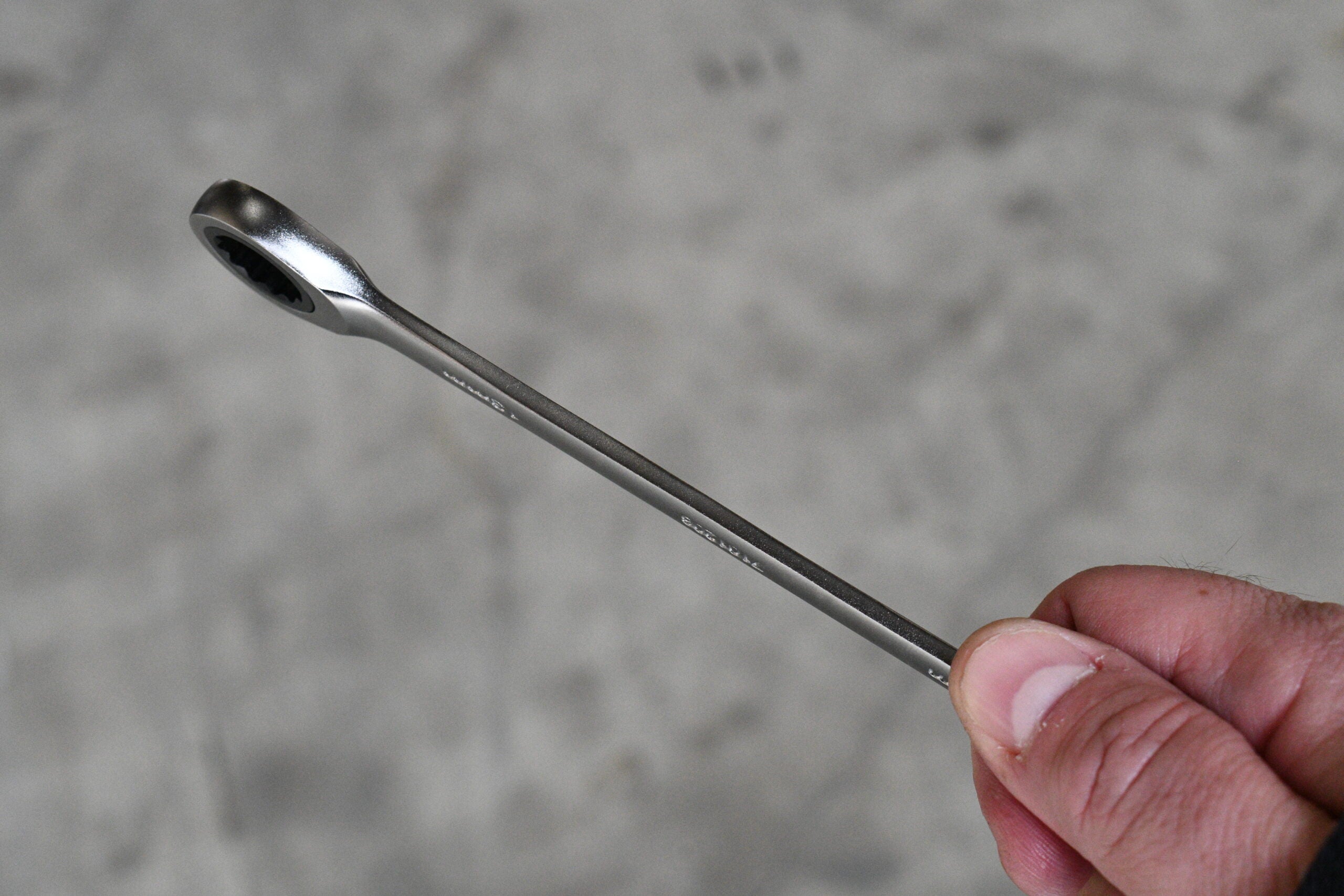 Close-up of Astro Pneumatic Razor super-thin ratcheting wrench being held showing slim profile