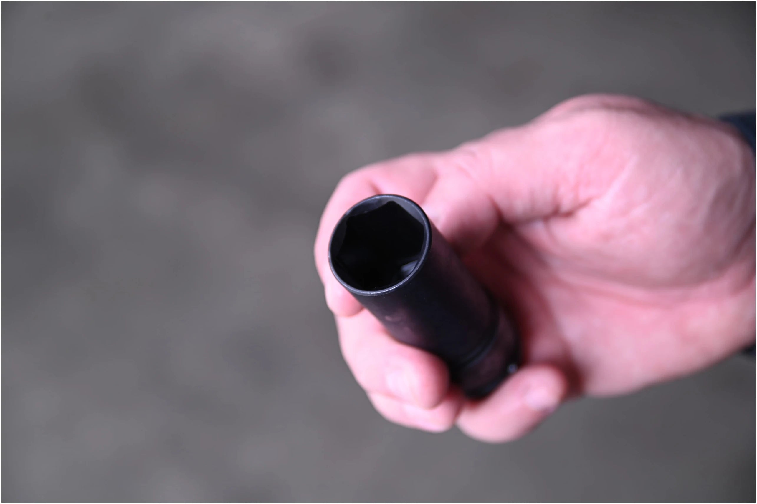 Close-up top view of Astro Pneumatic thin wall lug nut socket held in hand showing hex opening