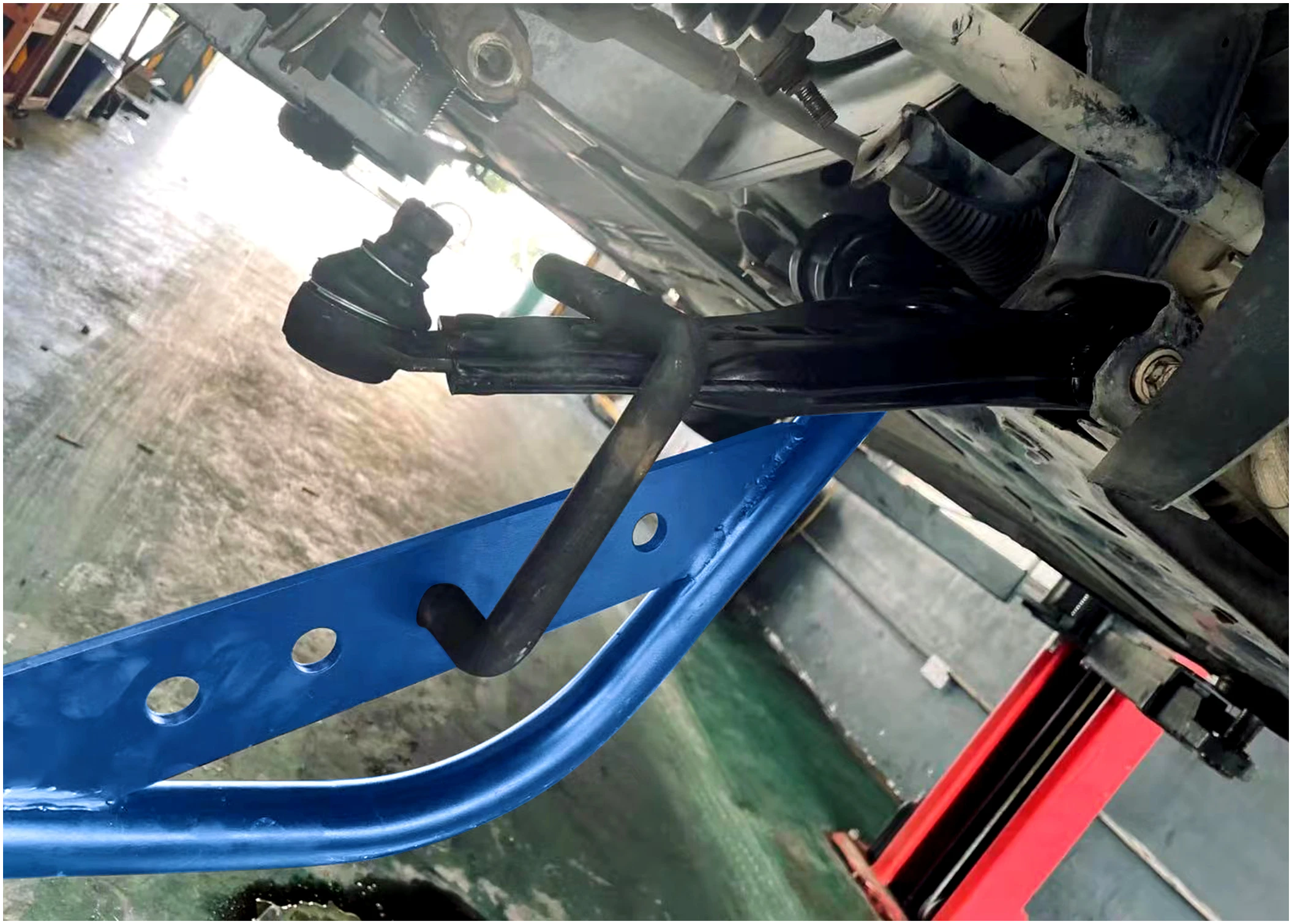 Astro Pneumatic 78914 Lower Control Arm 4ft Pry Bar in use separating lower control arm from knuckle