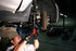 Mechanic using air hammer with retaining spring fitted under vehicle