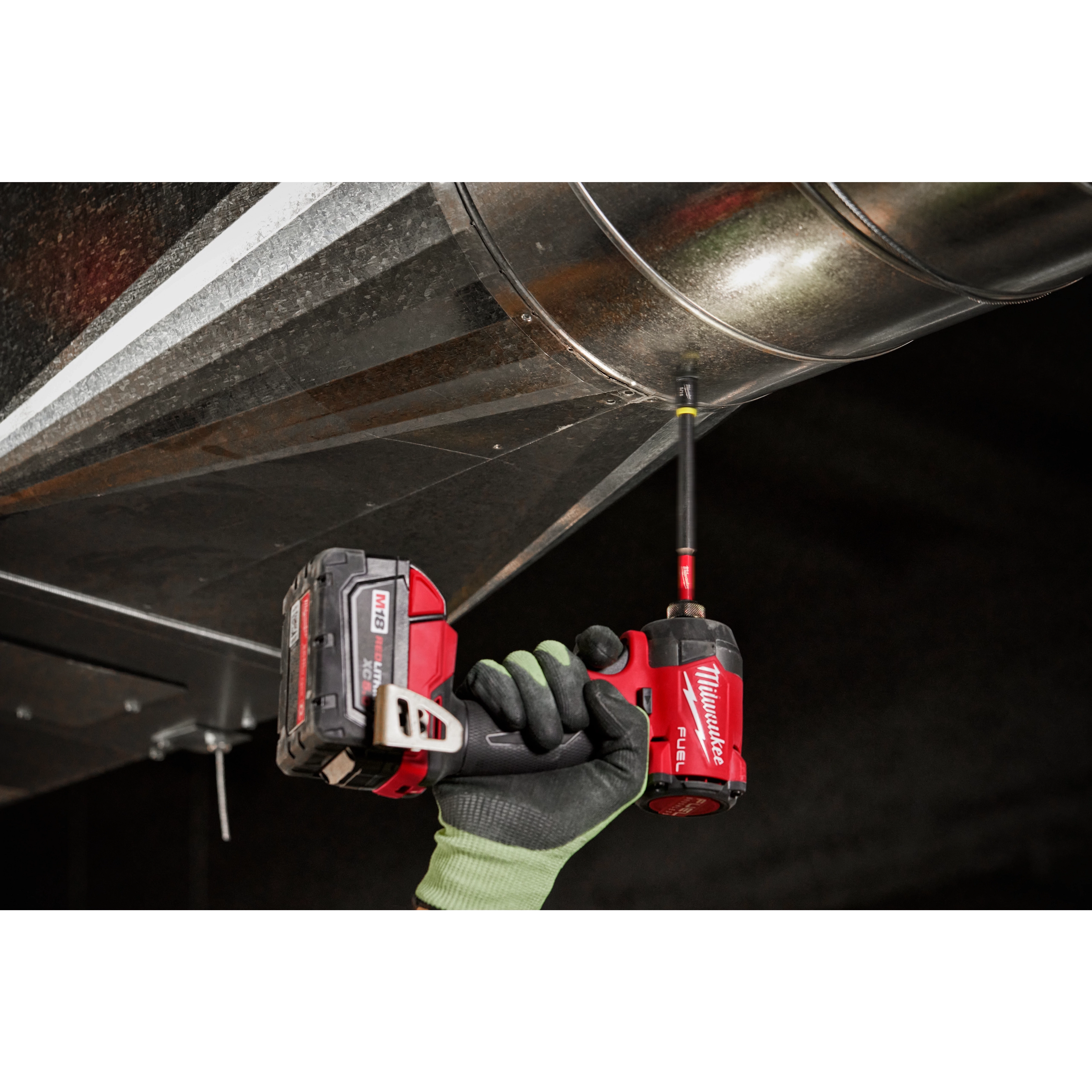 Milwaukee SHOCKWAVE 5/16" x 6" Magnetic Nut Driver driving fastener on overhead ductwork
