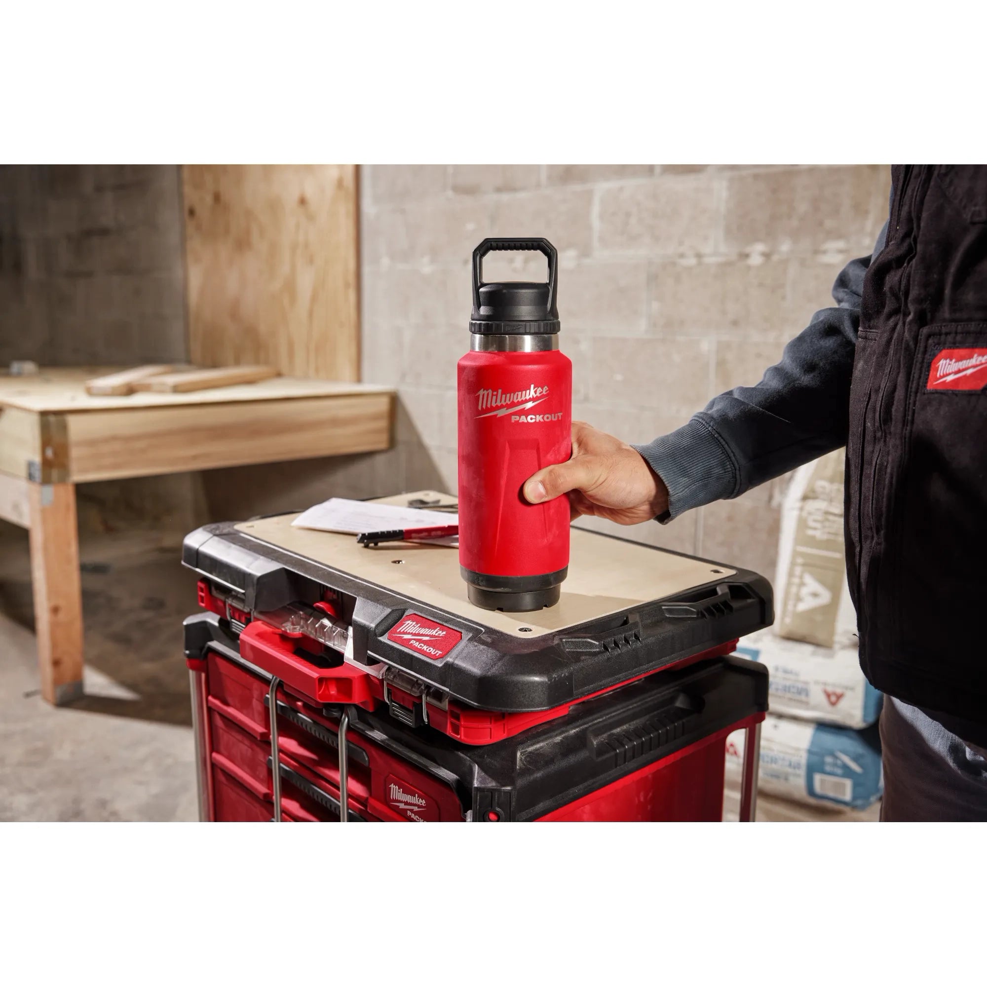 Milwaukee PACKOUT bottle being twisted and locked onto the PACKOUT Twist to Lock Mount mounted on a PACKOUT workbench in a jobsite environment