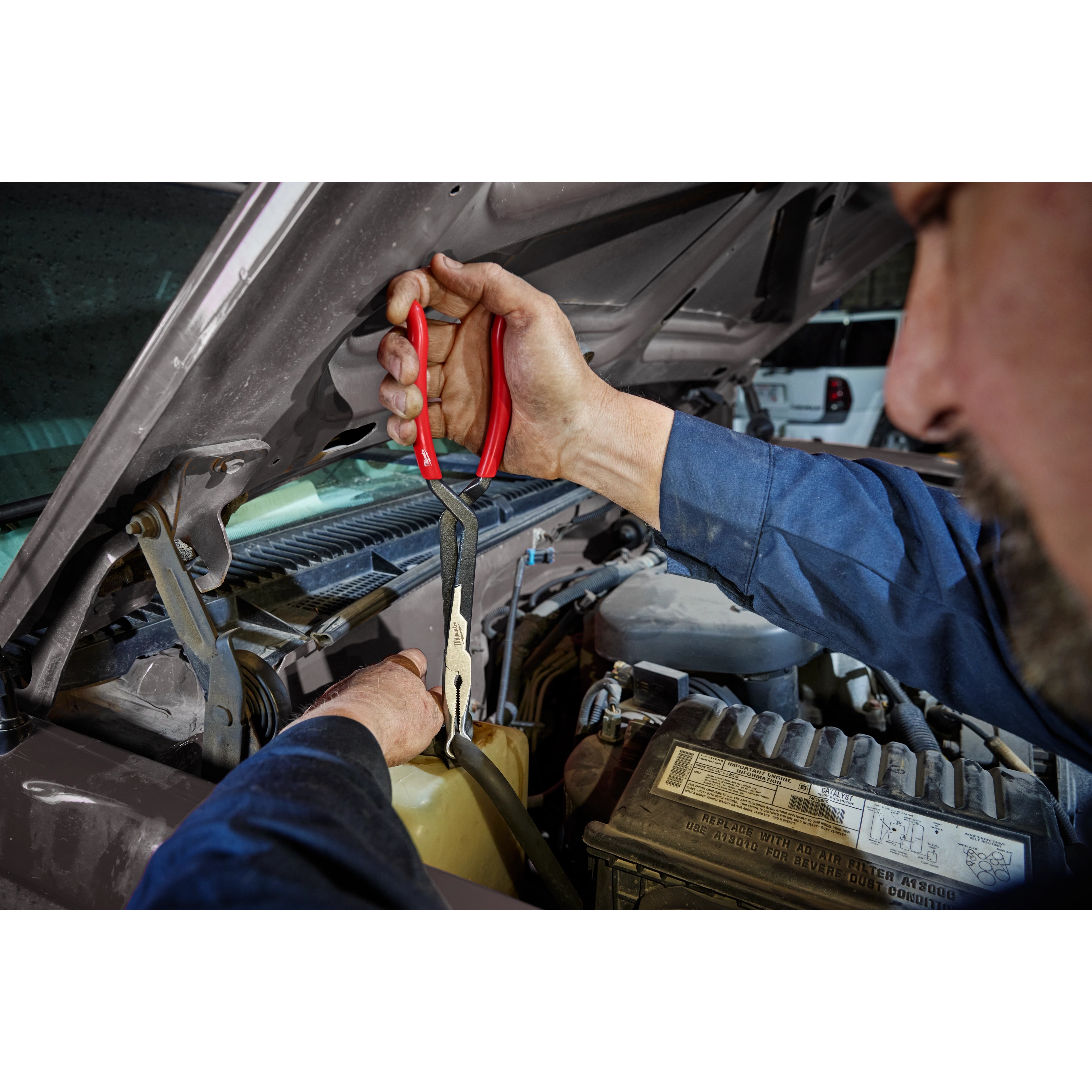Mechanic using Milwaukee 48-22-6563 Long Reach Hose Grip Pliers to access components under a vehicle hood