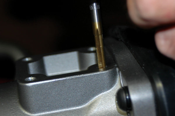 ATD Tools titanium coated tap being used for precision threading on a metal component