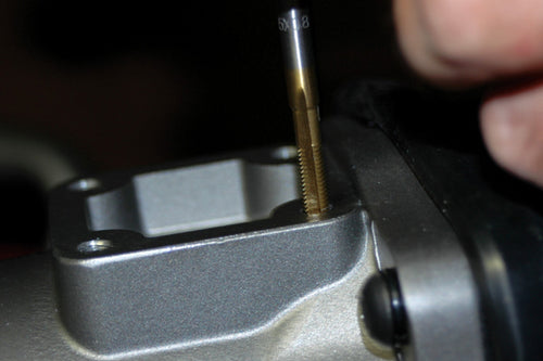 ATD Tools titanium coated tap being used for precision threading on a metal component