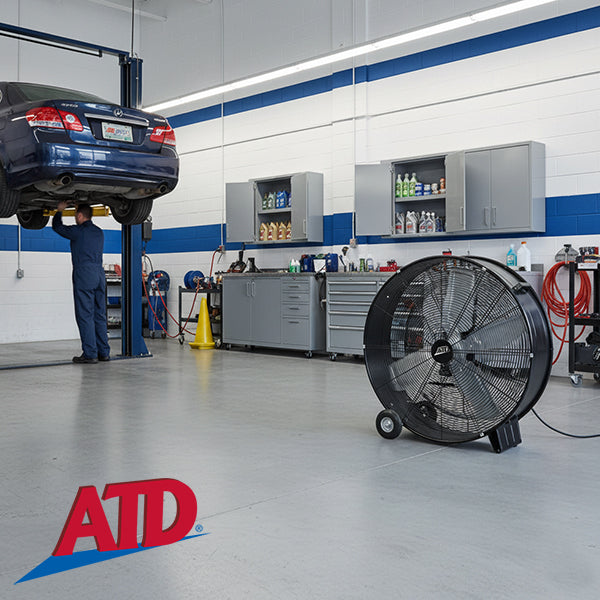 ATD Tools 36-Inch Direct Drive Drum Fan in use inside an automotive repair shop garage