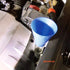 9 Circle oil funnel with extended refill bar inserted into tight engine compartment