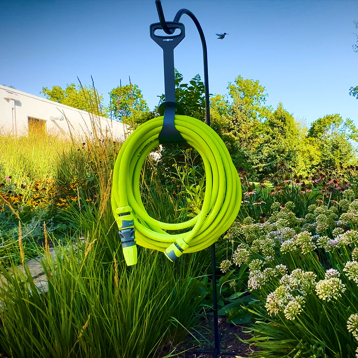 Flexzilla 50 ft. garden hose coiled on hose hanger mounted on garden post in outdoor setting
