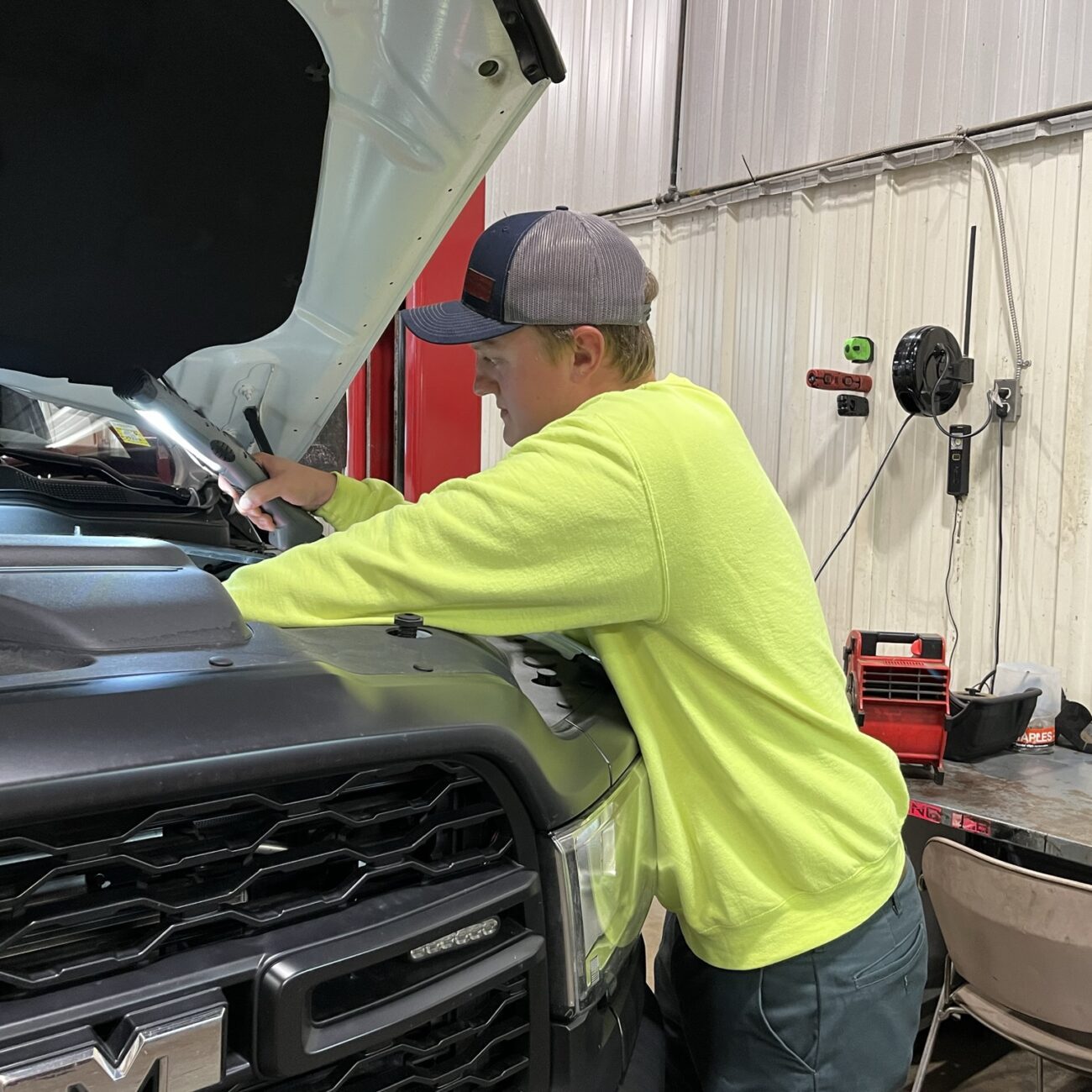 Alert Stamping 5030AM LED Work Light in use - mechanic working under vehicle hood in auto shop