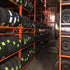 Martins Industries MLTFD Folding Tire Racks in warehouse use, rows of stacked passenger and light truck tires on orange racks