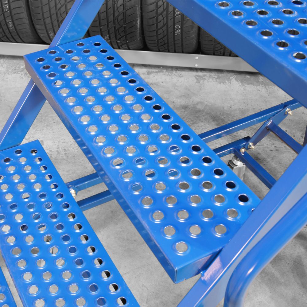 Close-up of MML-10 mobile ladder perforated steel grip steps with tyre rack in background