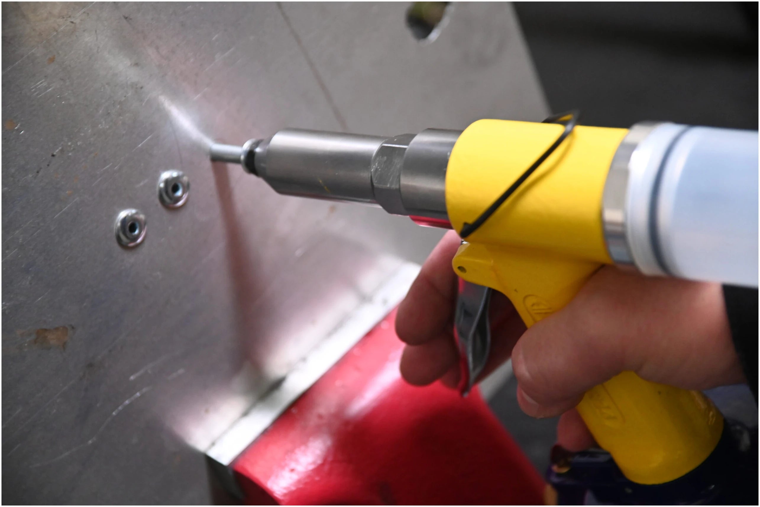 Astro Pneumatic PR14 Air Riveter in use setting a rivet on sheet metal panel