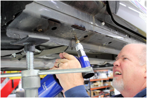 Astro Pneumatic PRN1 pneumatic rivet nut setter being used on vehicle undercarriage in shop
