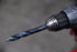 Astro Pneumatic TS21 TurboStep HSS patented drill bit loaded in drill chuck, in-use lifestyle photo