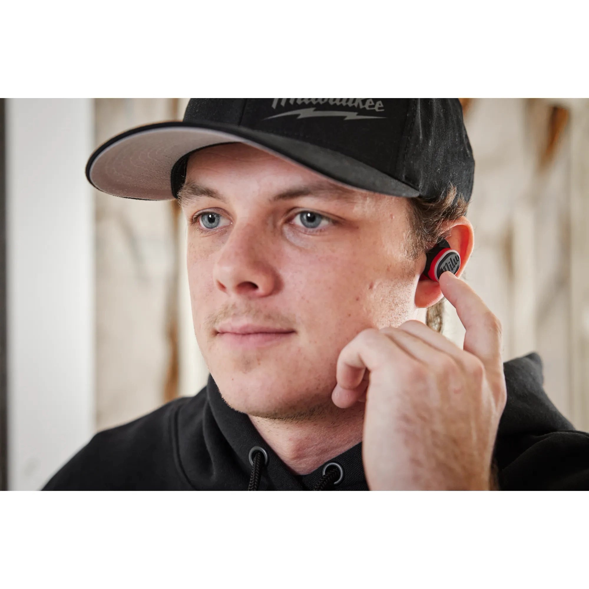 Man wearing Milwaukee REDLITHIUM USB Bluetooth Jobsite Earbuds with foam ear tips