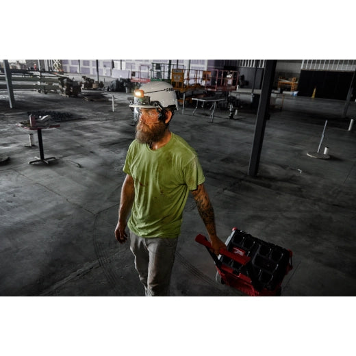 Worker carrying toolbox in warehouse wearing Milwaukee Tool 2118-21 BOLT REDLITHIUM USB Headlamp on hard hat