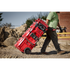 Milwaukee PACKOUT Rolling Tool Box being pulled across a rugged jobsite with stacked PACKOUT components