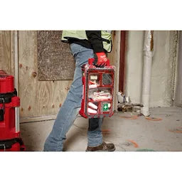 Worker carrying Milwaukee Tool PACKOUT First Aid Kit Type II on jobsite