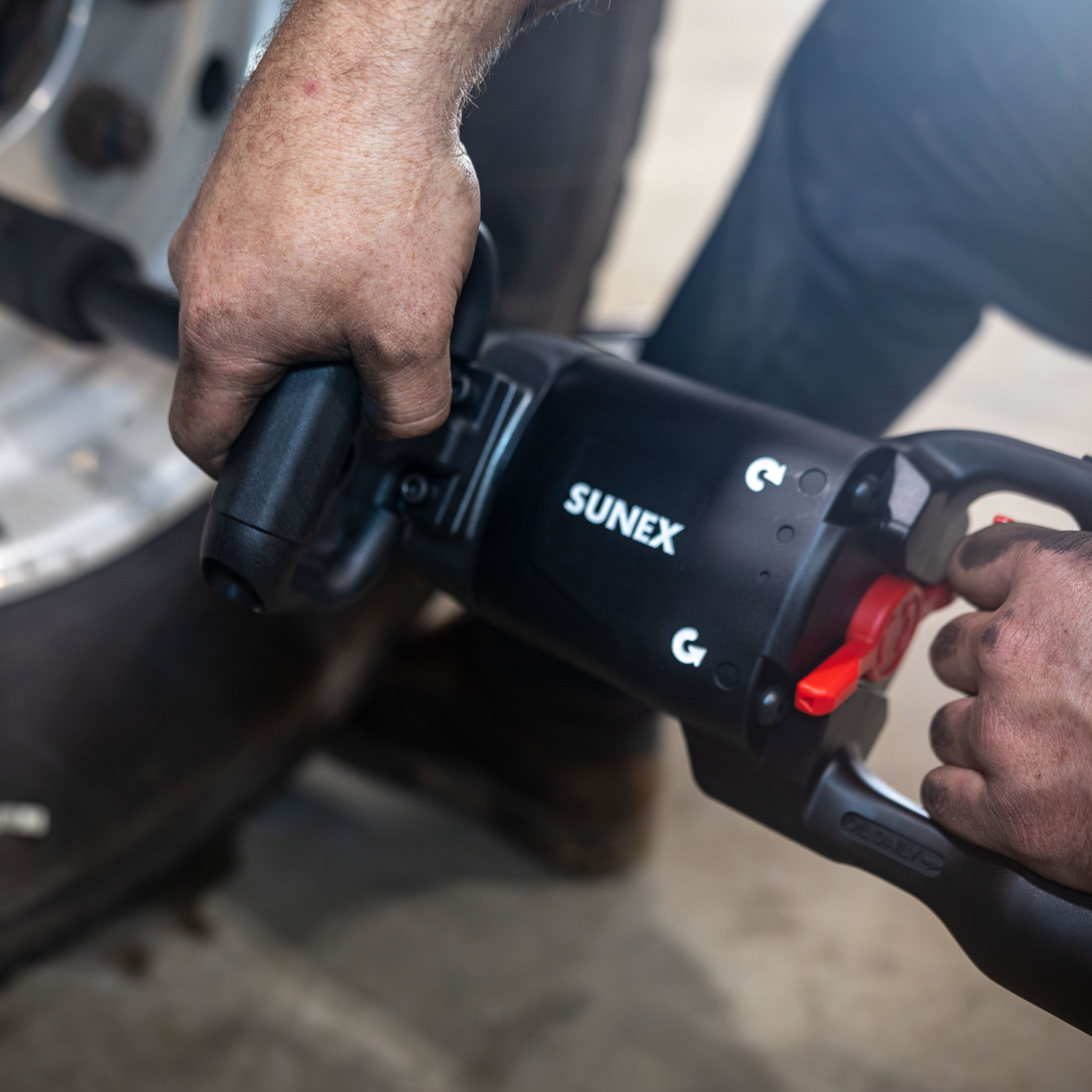 Sunex Tools SX01026 Magnesium Composite Impact Wrench being operated on vehicle axle in shop environment