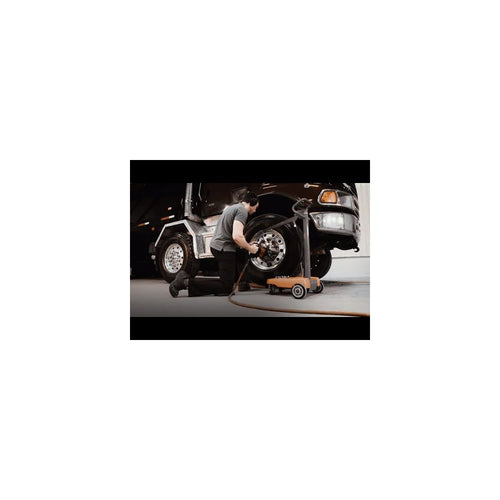 Technician using Martins Industries Impact Boom mobile impact wrench holder while servicing truck tires in a garage