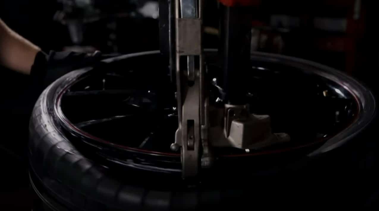 Coats 90C Leverless DuckHead mount and dismount system in use on tire