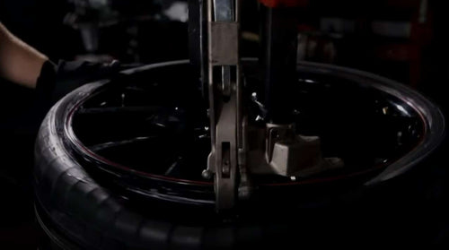 Coats 90C Leverless DuckHead mount and dismount system in use on tire