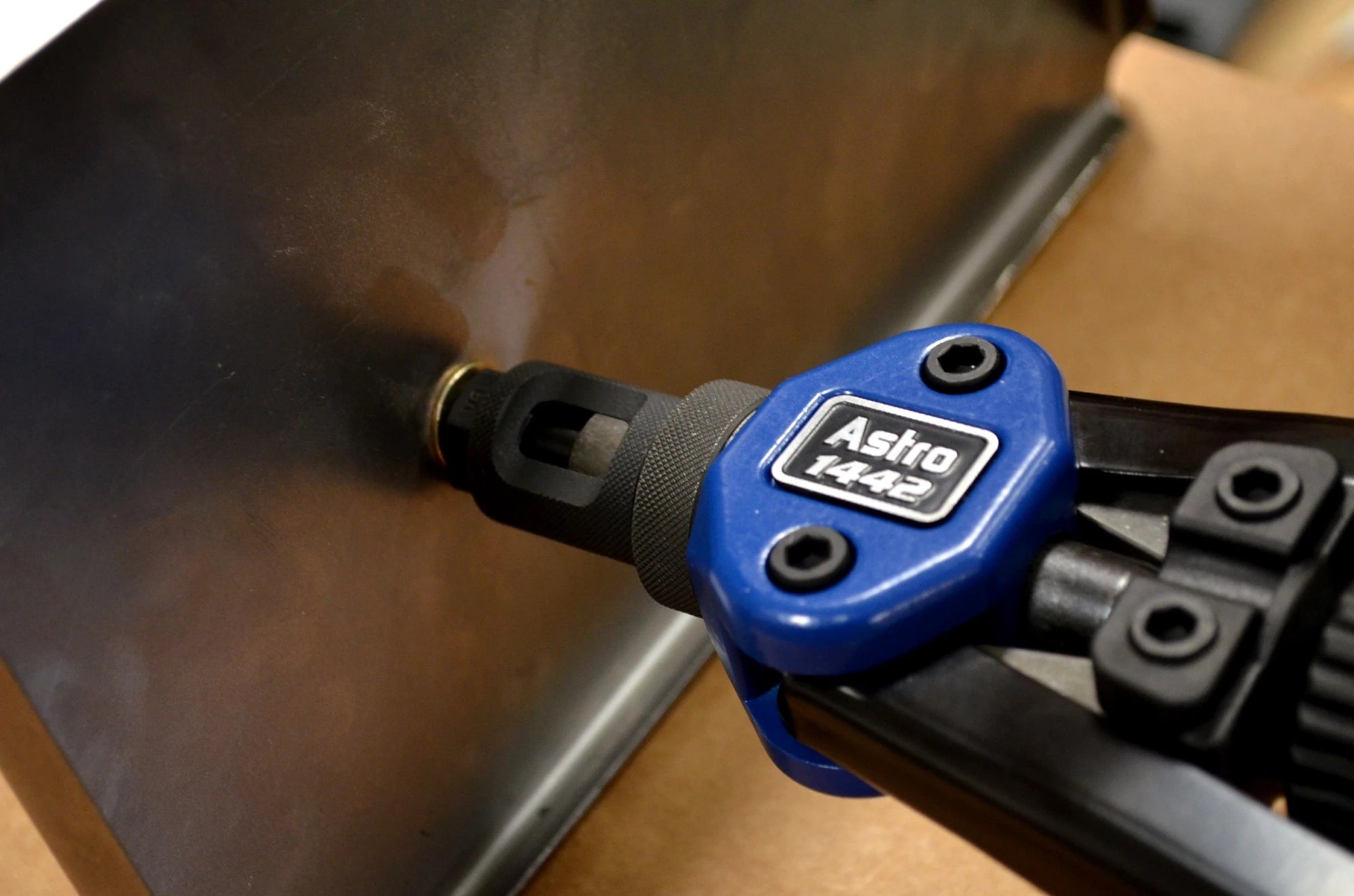 Close-up of Astro Pneumatic 1442 riveter nosepiece inserting a rivet nut into sheet metal