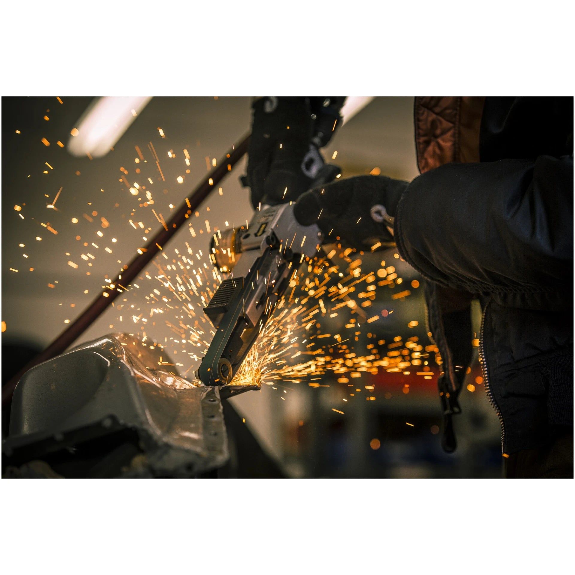 Astro Pneumatic 3035 Air Belt Sander action lifestyle shot with sparks
