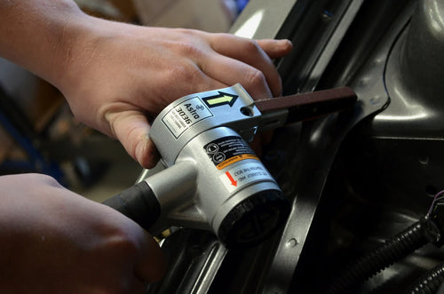 Astro Pneumatic AST-3036 Air Belt Sander in use on automotive panel - close-up