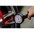 Astro Pneumatic AST-3081 Dial Gauge Tire Inflator checking tire pressure on a performance wheel close-up view