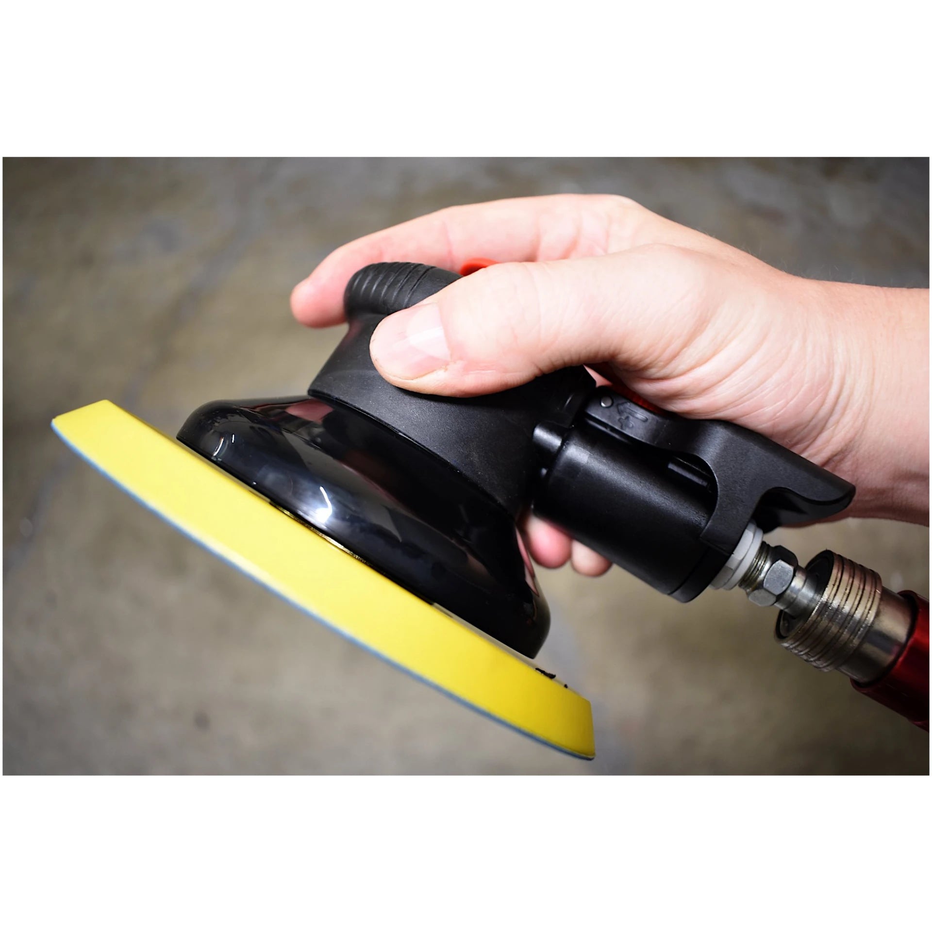 Astro Pneumatic AST-322P ONYX 6" Finishing Palm Sander in-hand side view with air hose attached