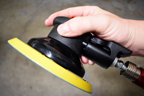Astro Pneumatic AST-322P ONYX 6" Finishing Palm Sander held in hand with air hose connected