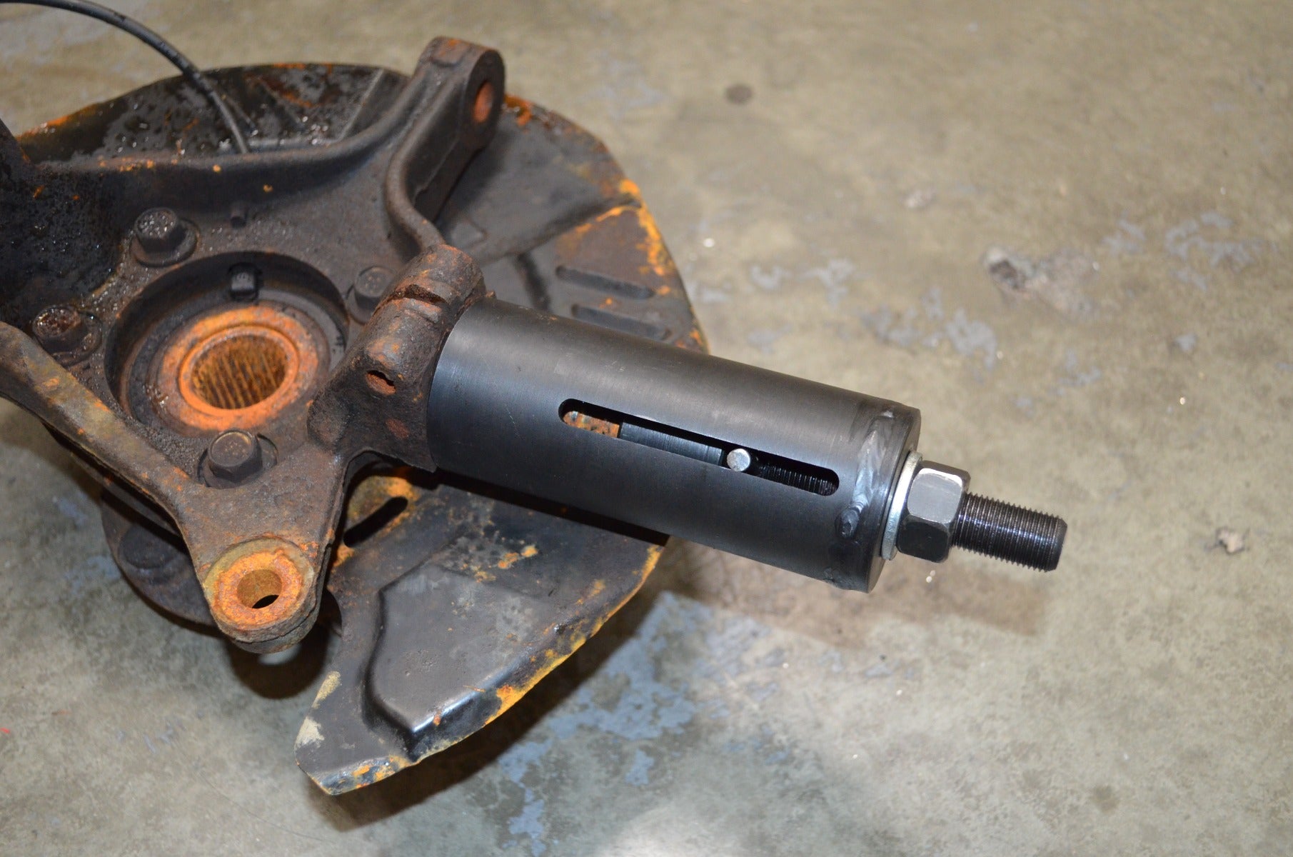 Astro Pneumatic 78620 ball joint puller inserted into Subaru steering knuckle for removal