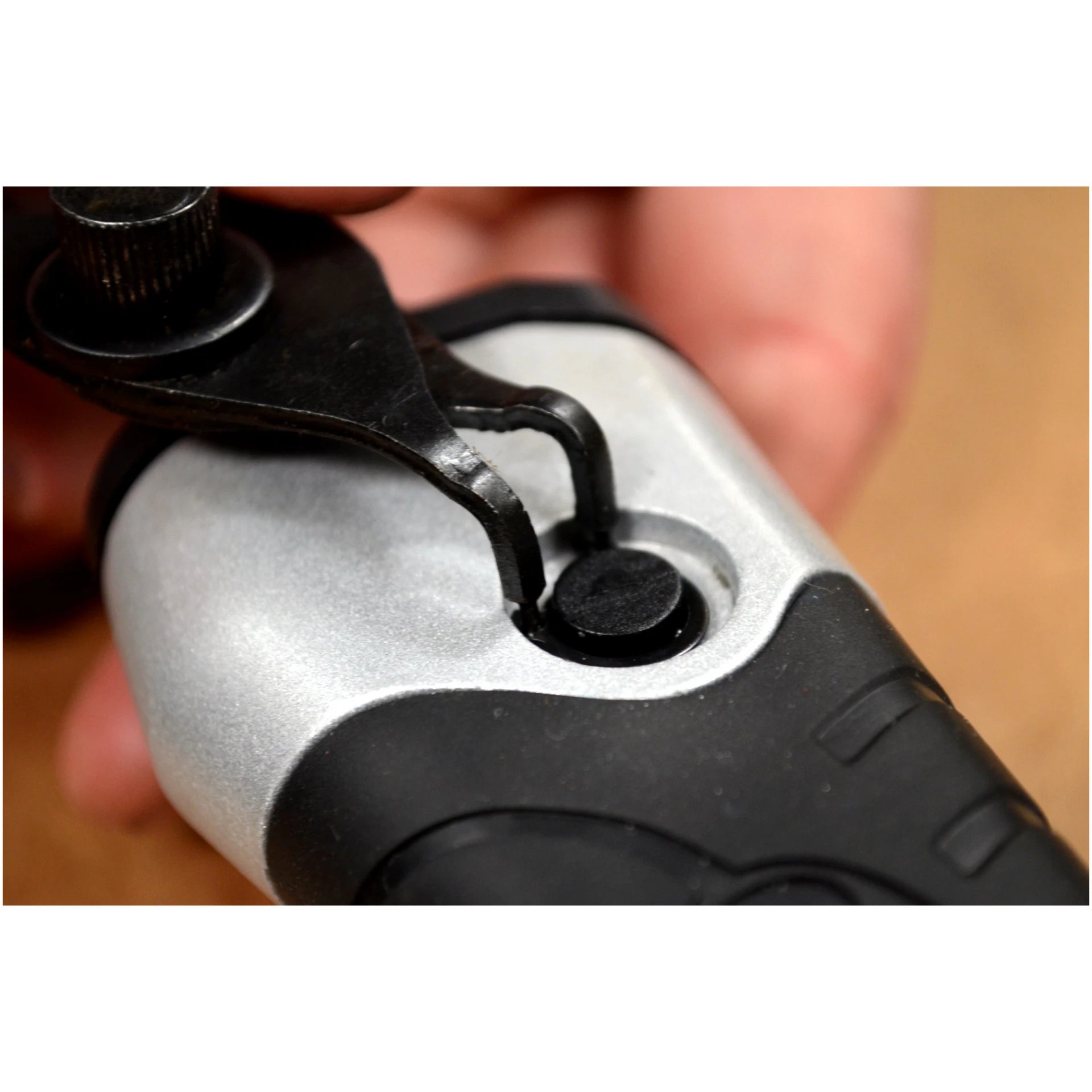 Close-up of snap ring pliers engaging a snap ring on a tool component