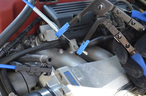 Astro Pneumatic 94093 Multi-Cable Hose Clamp Pliers in use on automotive engine hose clamps