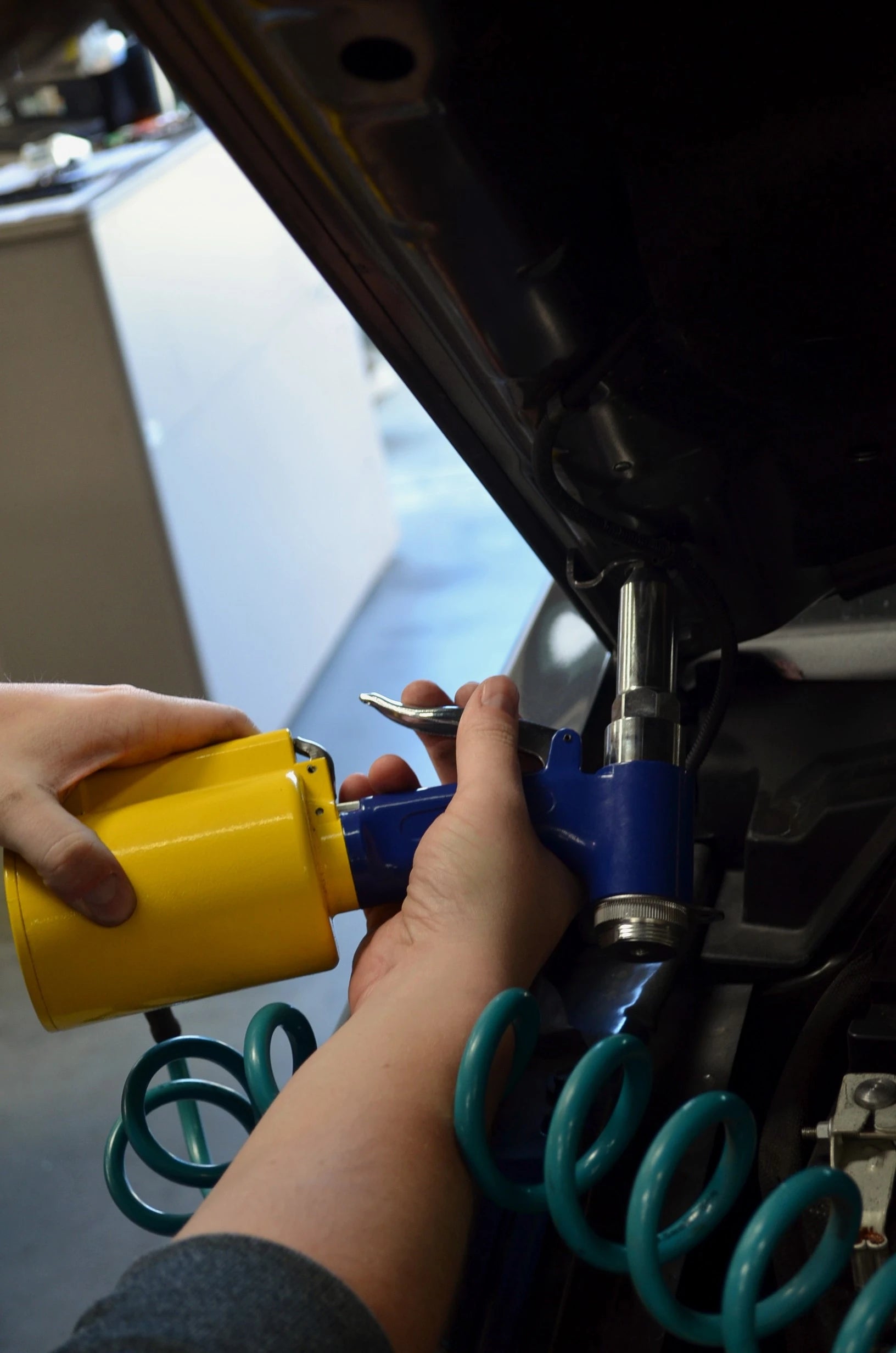 Astro Pneumatic PR36 Air Riveter in use under vehicle hood, close-up action shot